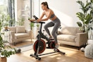 Lifestyle image of Naipo Exercise Bike being used indoors by a large window