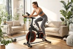 Lifestyle image of Naipo Exercise Bike being used indoors by a large window