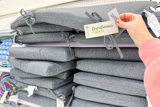 hand grabbing a threshold patio cushion off a target shelt