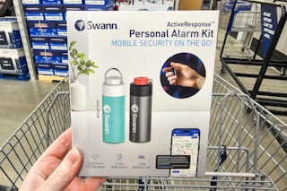 person holding a personal alarm kit over a cart