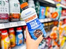 hand holding a bottle of dunkin cold brew coffee in walmart aisle