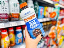 hand holding a bottle of dunkin cold brew coffee in walmart aisle