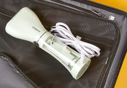 a green garment steamer in a suitcase