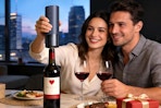 couple using wine opener at table
