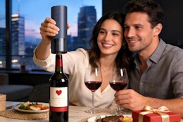 couple using wine opener at table