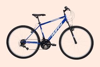 blue huffy mountain bike on a peach background