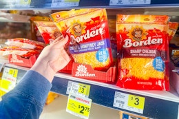 hand grabbing a bag of borden shredded cheese