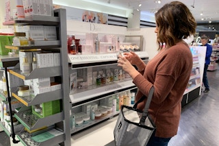 Woman trying Dior skin care from test container in Sephora.