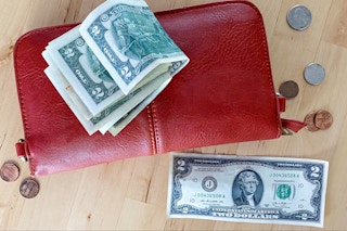 a two dollar bill with coins and a wallet