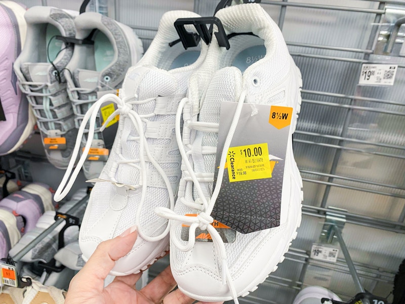 hand holding a pair of womens avia shoes at walmart