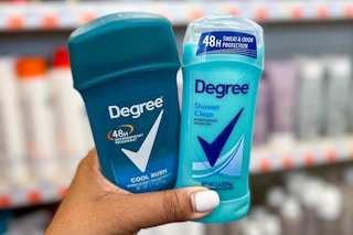 hand holding two sticks of degree deodorant