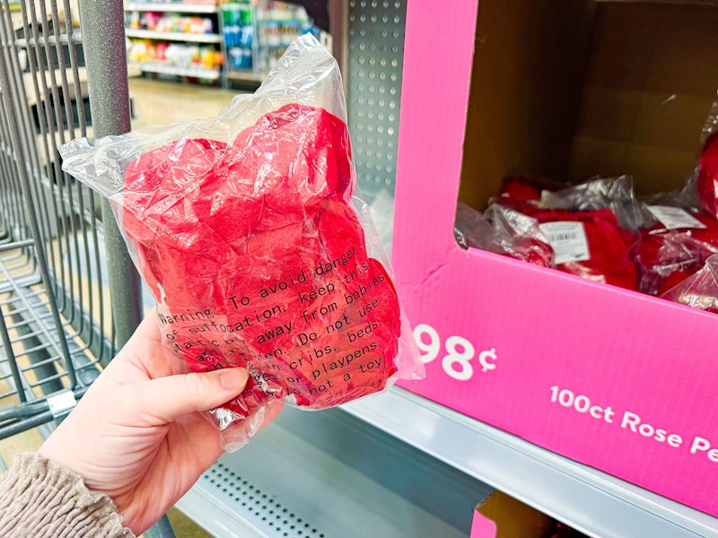 hand holding a pack of rose petals at walmart