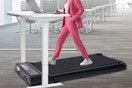 a woman walking on a treadmill at a desk