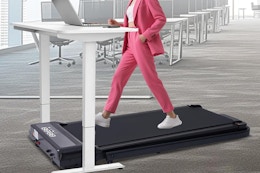 a woman walking on a treadmill at a desk