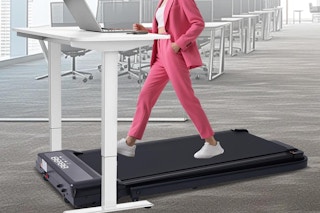 a woman walking on a treadmill at a desk
