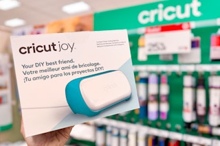 hand holding a cricut joy in front of signage at target