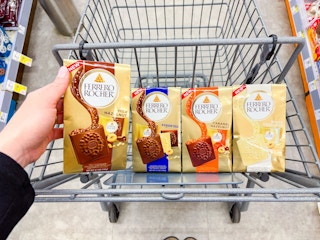 hand holding a ferrero rocher candy bag above a walgreens cart