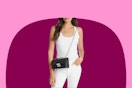 picture of a woman from the middle of her face to just above her knees wearing a black and silver small Michael Kors Tribeca bag diagonally