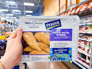 hand holding a pack of perdue chicken strips