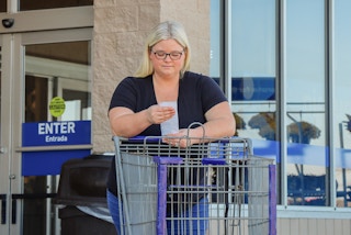 a person holding up a receipt outside of lowes