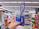 hand holding crest and oral-b items in walgreens