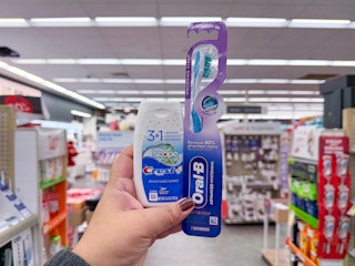 hand holding crest and oral-b items in walgreens