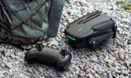 a drone and controller next to a backpack