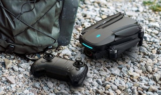 a drone and controller next to a backpack