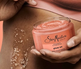 a person holding a jar of pink body scrub