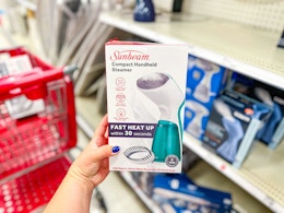 hand holding a sunbeam handheld steamer at target