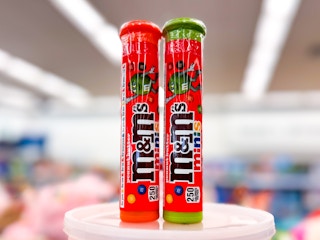 two tubes of m&m minis on a round platform at the store