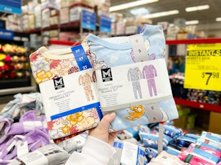 person holding up 2 4-piece kids pajama sets