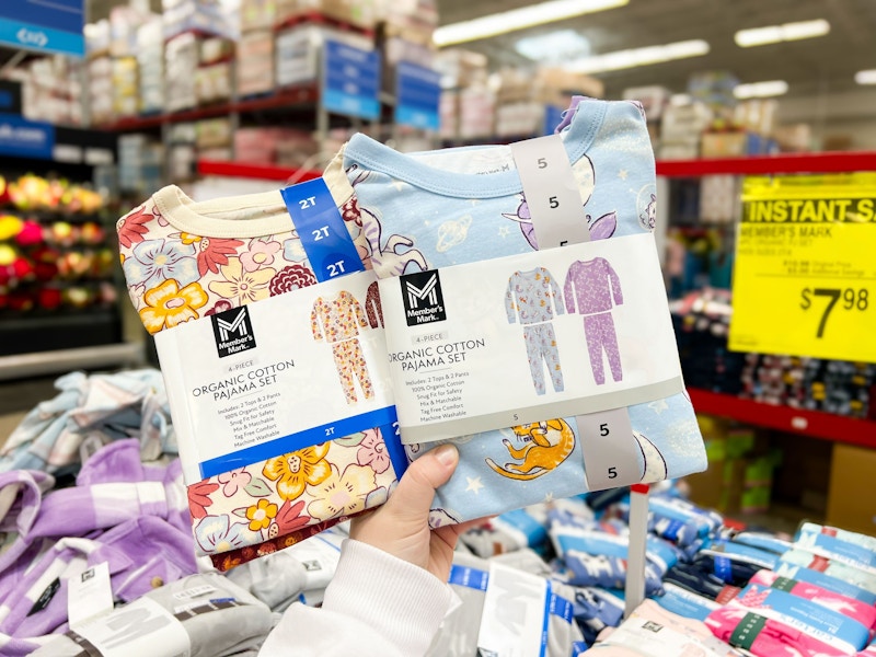 person holding up 2 4-piece kids pajama sets