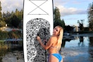 a woman standing next to her paddleboard
