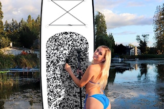 a woman standing next to her paddleboard