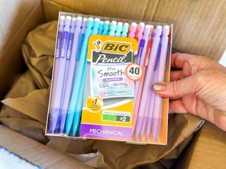 a hand holding a pack of mechanical pencils