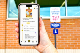 hand holding smartphone with kcl app 1-clip deal in front of walgreens curbside pickup sign