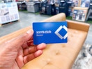 Hand holding a Sam's Club Card in front of Furniture