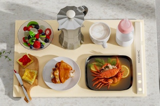 Electric warming mat has various food items on it