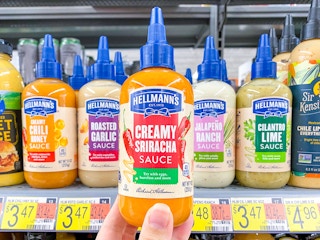 Hellmann's Creamy Siracha Sauce held in front of shelf at Walmart