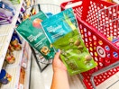 hand holding 3 good & gather organic dried fruit snacks in front of target cart