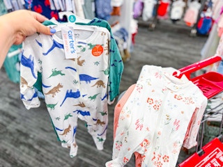 hand hold a sleep & play set in the baby apparel target department