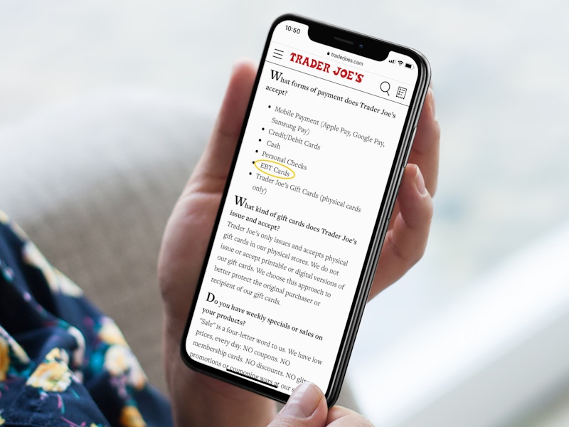 person with iphone looking at trader joes accepted forms of payment screenshot
