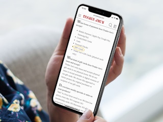 person with iphone looking at trader joes accepted forms of payment screenshot