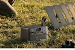 portable power station charging items on grassy area