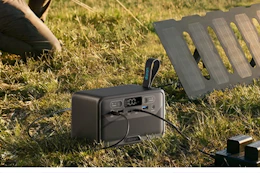 portable power station charging items on grassy area