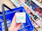 hand holding loreal paris hydra renewal facial moisturizer over walmart hand cart