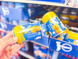 hand holding a tube of pillsbury grands biscuits in walmart aisle
