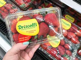 hand holding carton of strawberries