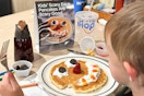 a child holding a fork about to eat a ihop scary pancake